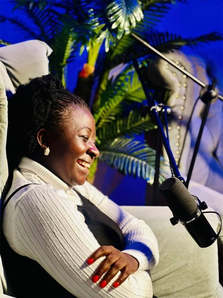 Counselor Deborah smiling beside a studio microphone during a radio interview