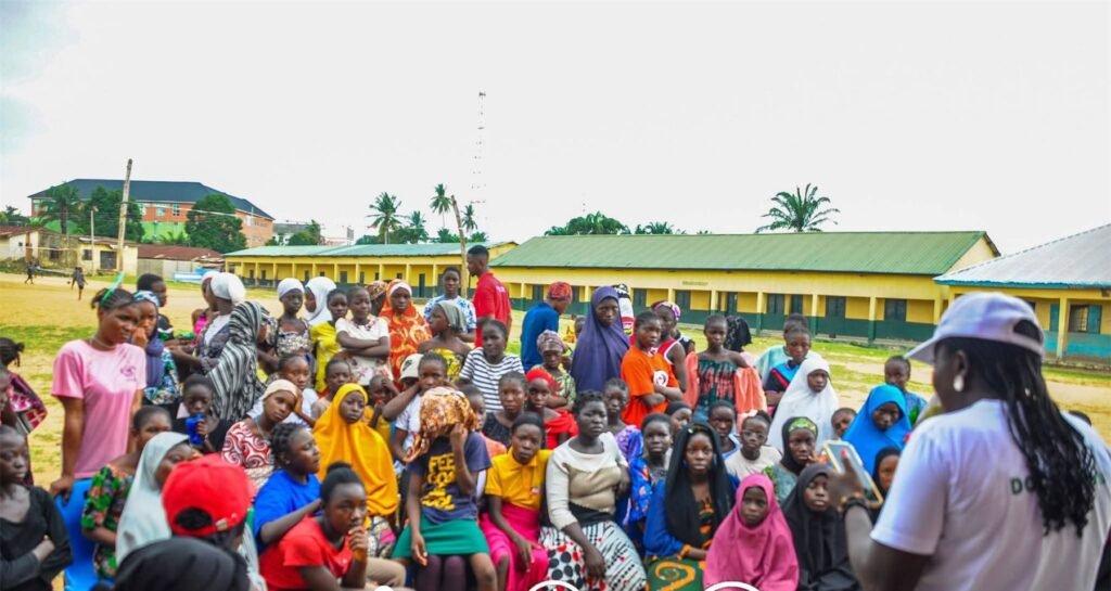 Counselor Deborah addressing a large community gathering outdoors