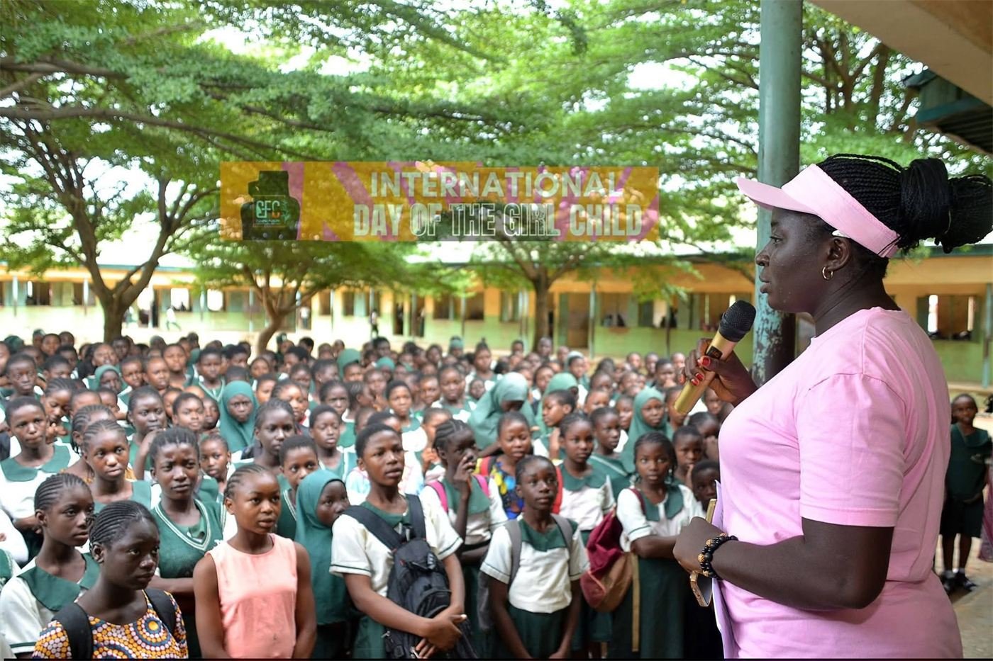 Counselor Deborah Baba speaking to a large gathering of secondary school students outdoors
