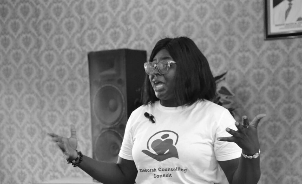 Counselor Deborah gesturing as she speaks, wearing a DCC T-shirt