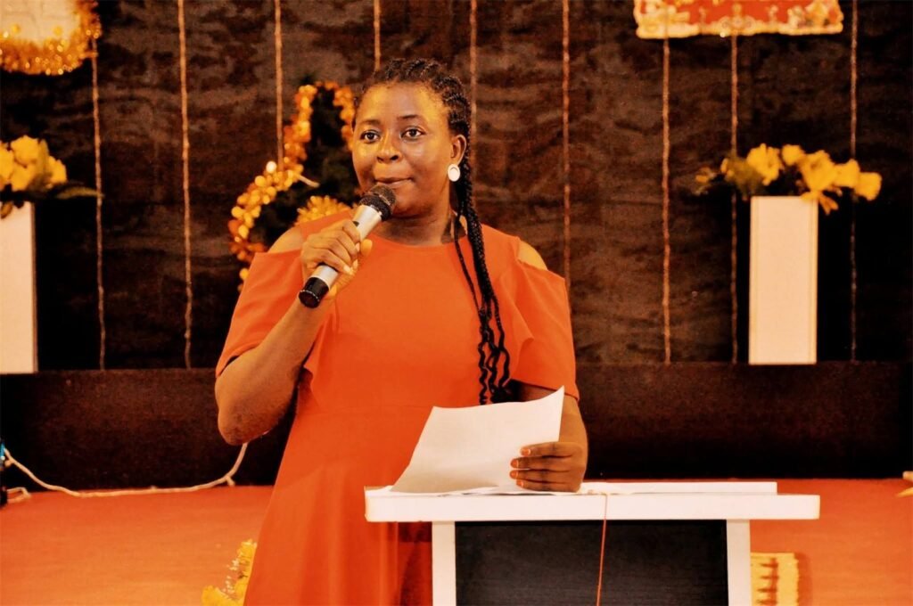 Counselor Deborah speaking on stage with a microphone